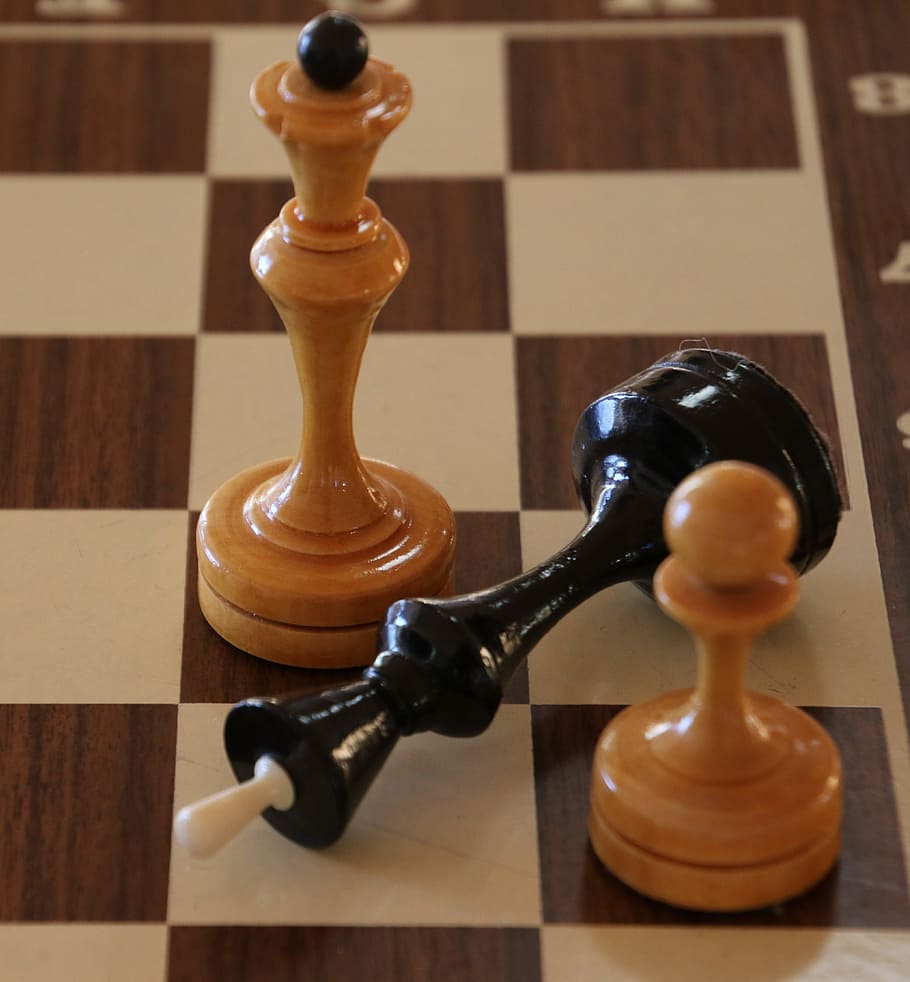 black king chess piece in between two brown chess pieces, Match