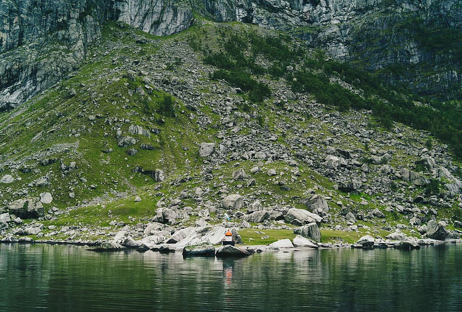 body of water beside gray and green mountain during daytime, mountain peak near body of water HD wallpaper