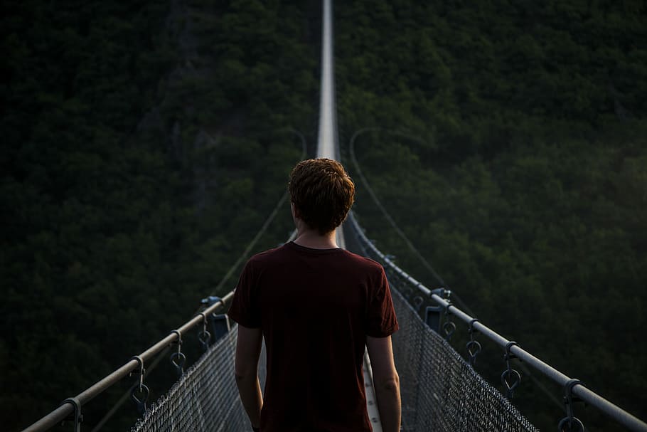 man standing alone on hanging bridge, man on hanging bridge at daytime