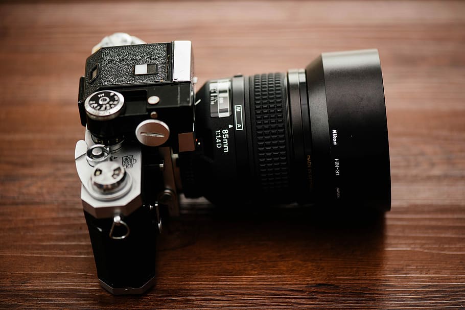black SLR camera on brown wooden table, black MILC camera on brown table HD wallpaper