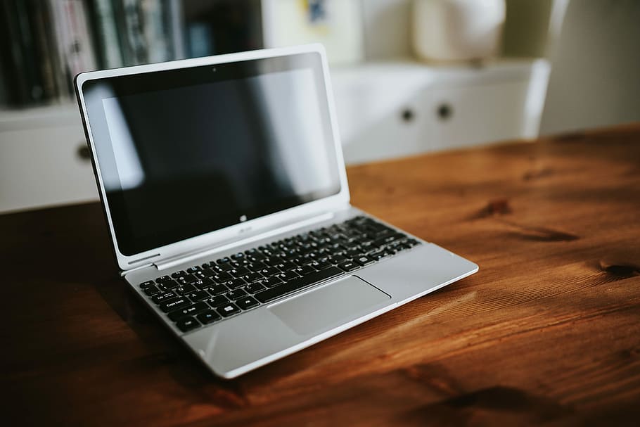 Silver laptop with various items on a table, magazines, computer HD wallpaper