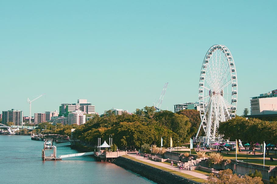 landscape photography of city near river, Ferris wheel near wooden dock HD wallpaper
