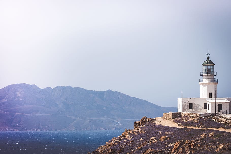 white lighthouse, white lighthouse on hilltop in front of body of water HD wallpaper