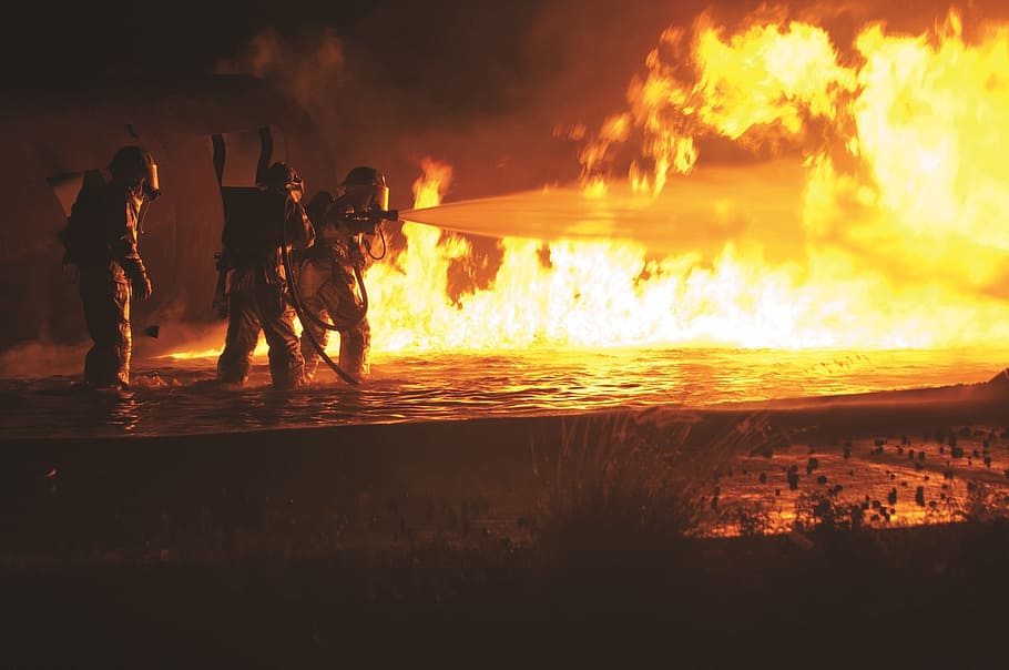 three fire fighters holding water hose in front of flames, firefighters HD wallpaper