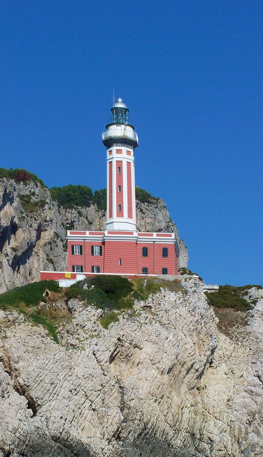 lighthouse, rock, sky, blue, red, coast, tower, blue sky, clear sky HD wallpaper