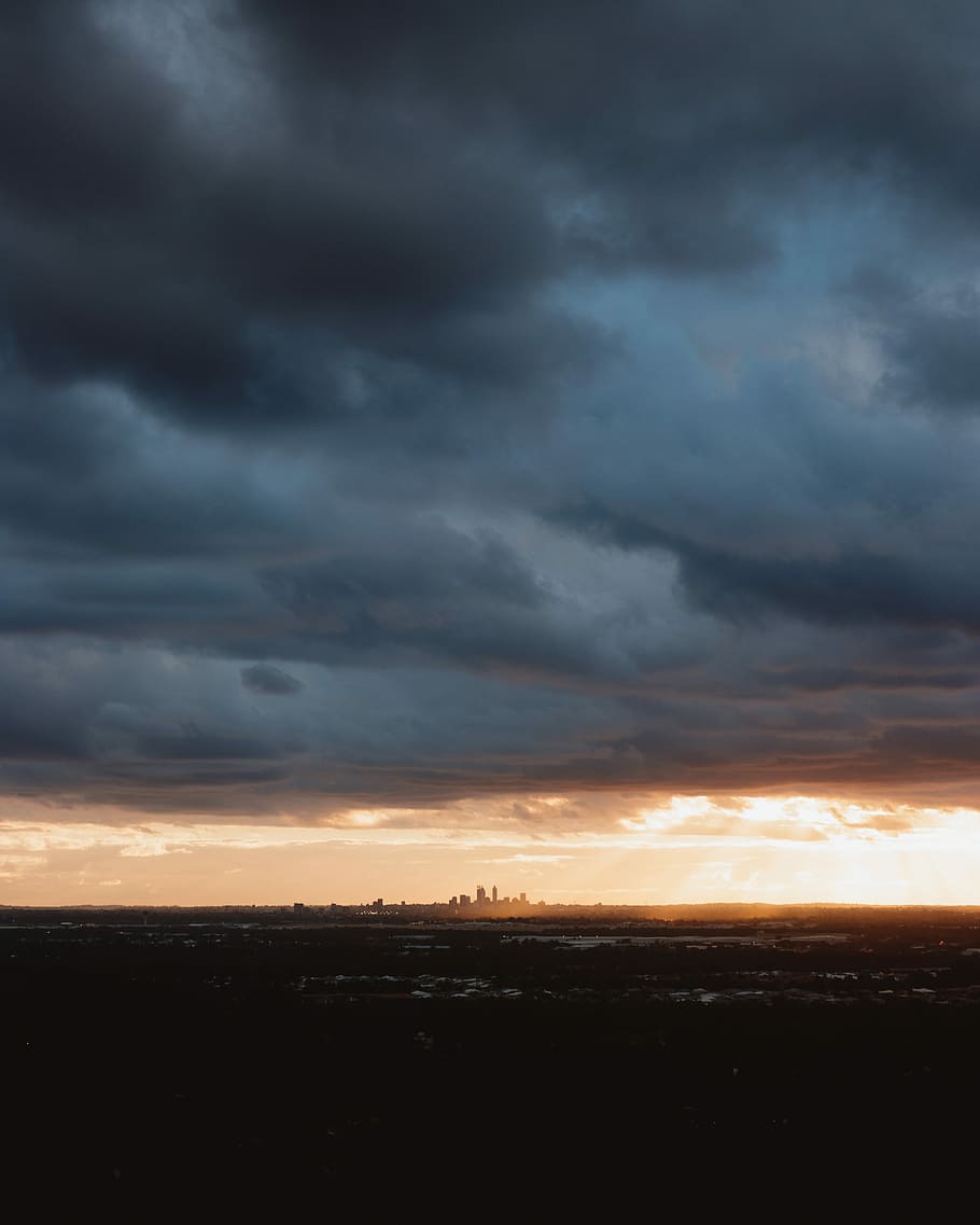 cloudy sky above cityscape, silhouette of city under dark sky HD wallpaper