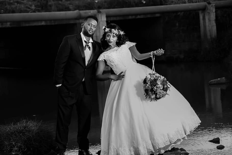 bride and groom taking group picture, grayscale photo of groom and bride