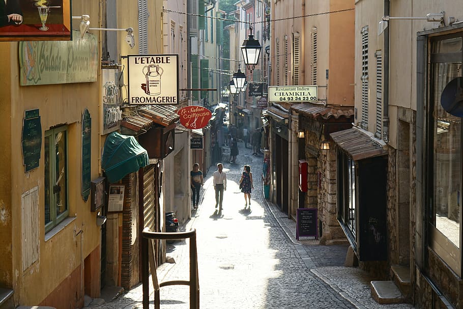 man and woman walking in street corner, town, cobblestone, shop HD wallpaper