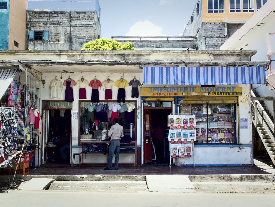 person stands in front of building, man standing in front of clothes store HD wallpaper