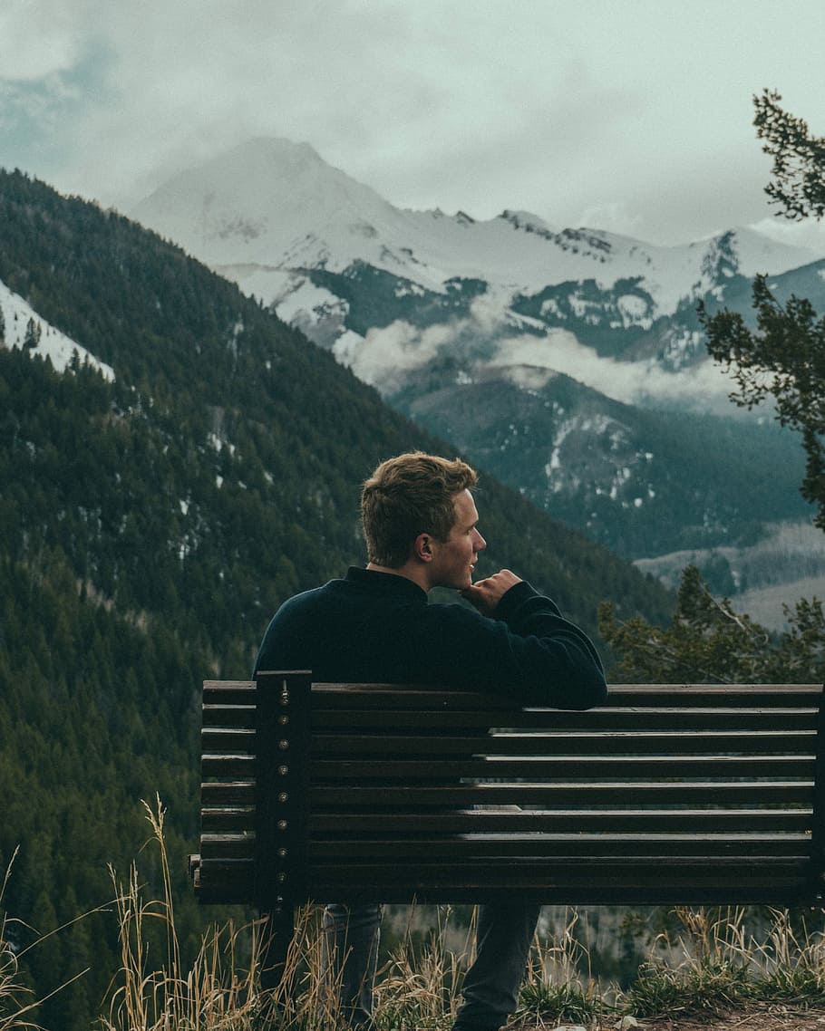 image contains man sitting on bench near mountains, men, outdoors HD wallpaper