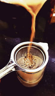 brown liquid filtered by stainless steel strainer to clear drinking glass HD wallpaper