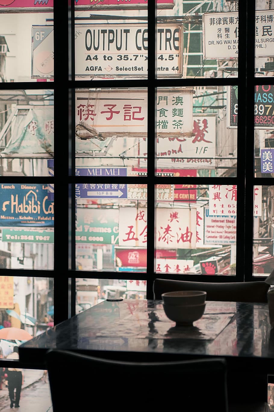 view of assorted signages through window, brown bowl on wooden table near window HD wallpaper