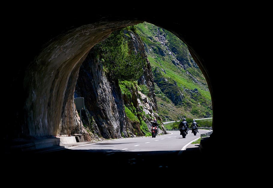 three person riding motorcycle about to enter tunnel during daytime HD wallpaper