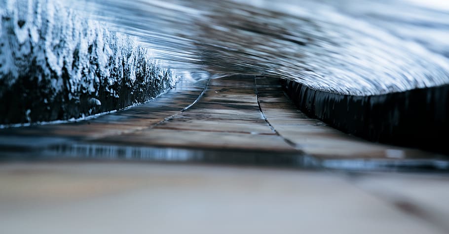 A close up shot of water flowing along a path in the shape of a tunnel, brown pathway on macro shot HD wallpaper