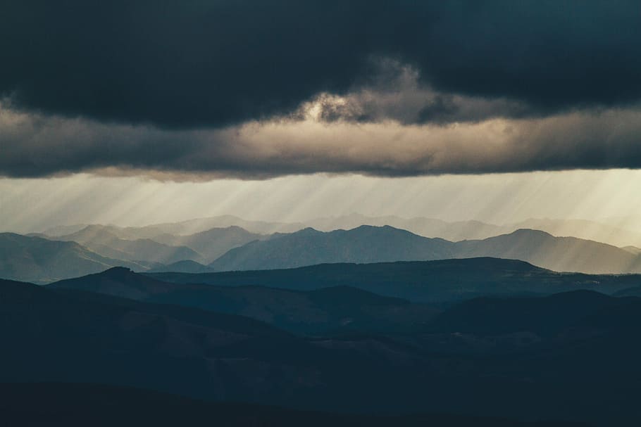 mountains and sun rays lanscapes, black hills under grey cloudy sky HD wallpaper