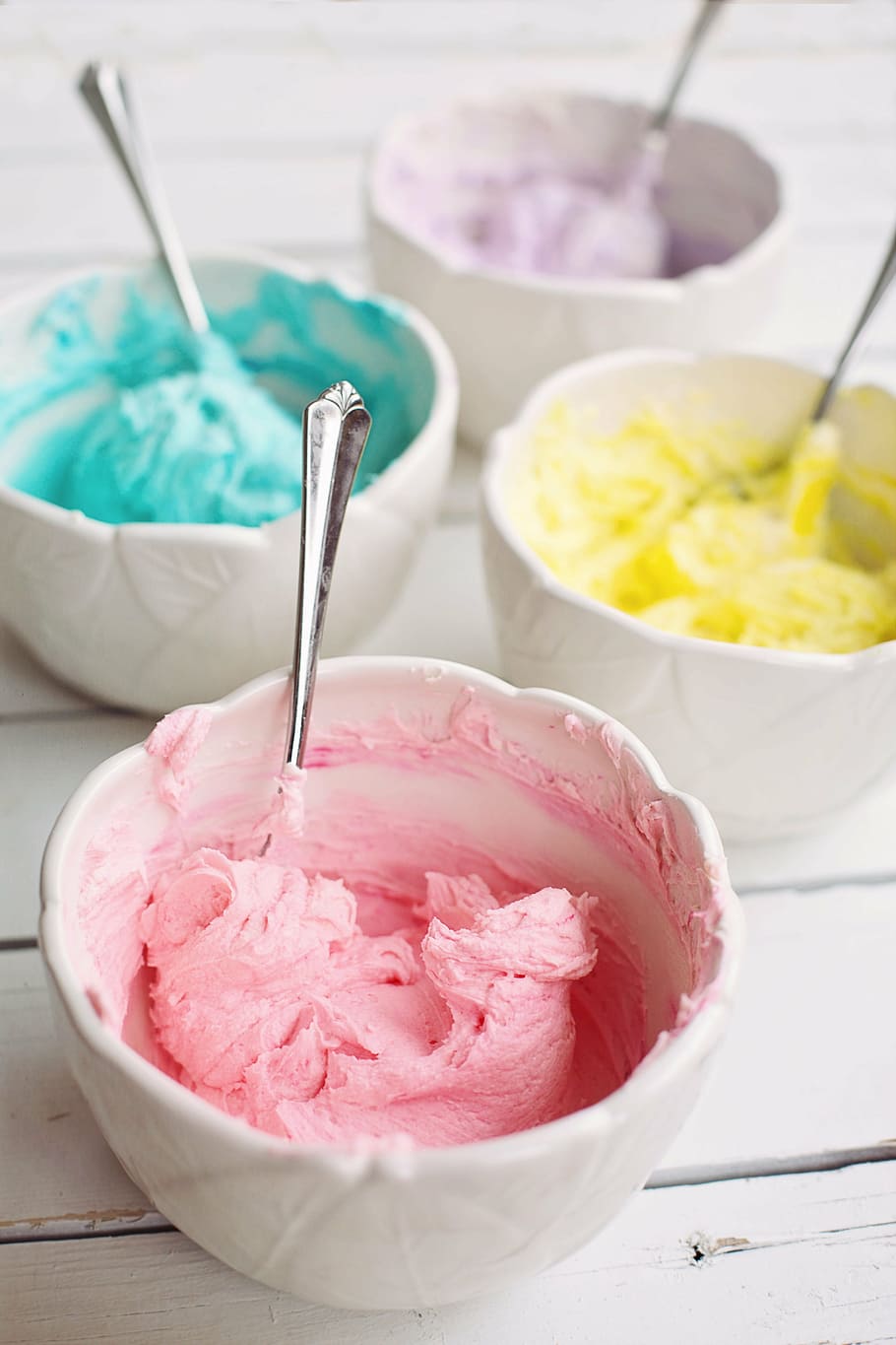 pink, purple, teal, and yellow ice creams on white ceramic bowls with four stianless steel spoons HD wallpaper