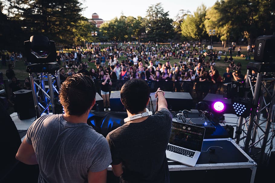 two men on stage with people watching at daytime, dj, entertainment