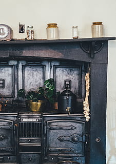 brown wooden kitchen shelf with ceramic jars on top, black wooden cabinet with shot glasses on top and black metal water dispenser HD wallpaper
