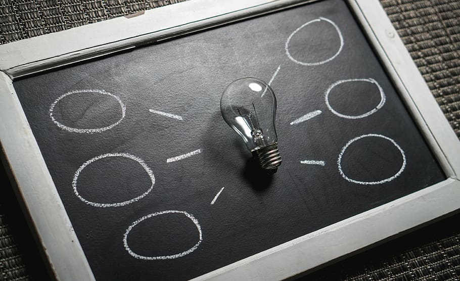 clear glass filament bulb on blackboard, idea, innovation, imagination