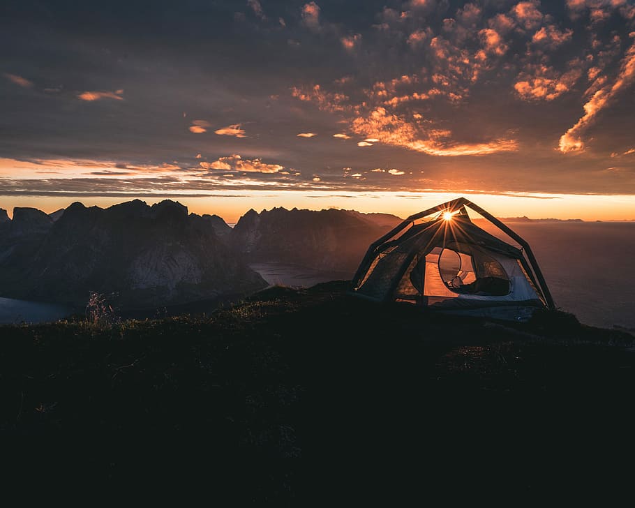 Sunrise over Lofoten Islands, lanscape photo of a person using tent on sunrise