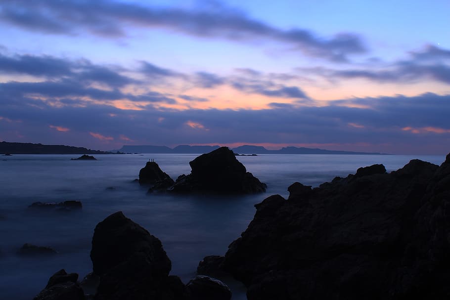 silhouette photo of mountains, cliff near body of water at cloudy sky HD wallpaper