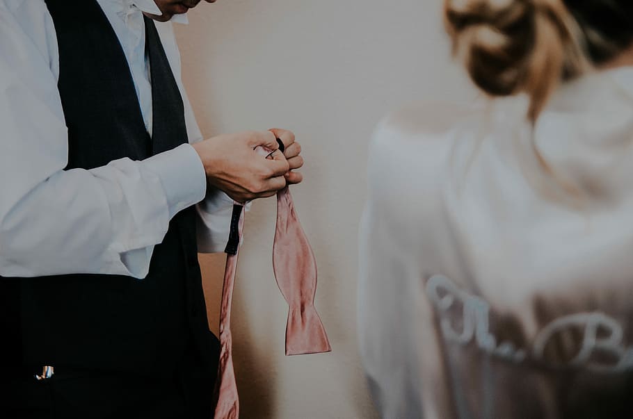 man holding a pink textile inside white room, person holing pink necktie HD wallpaper