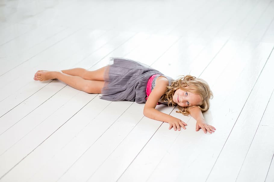 girl in grey sleeveless dress lying on white floor, relax, young