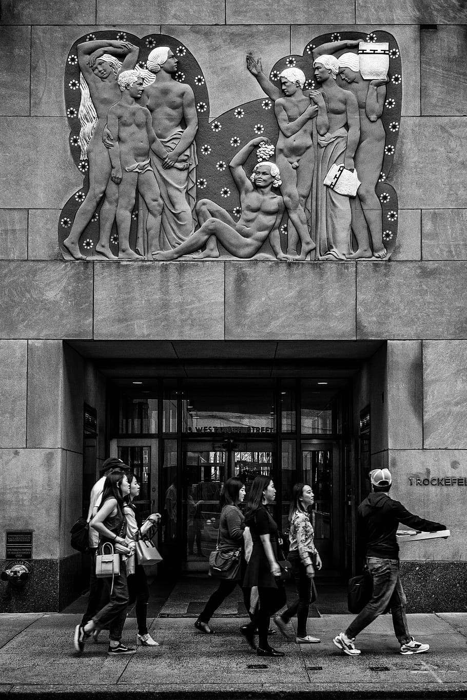 grayscale photography of people walking under sculpted wall, grayscale photo of people walking at the sidewalk HD wallpaper