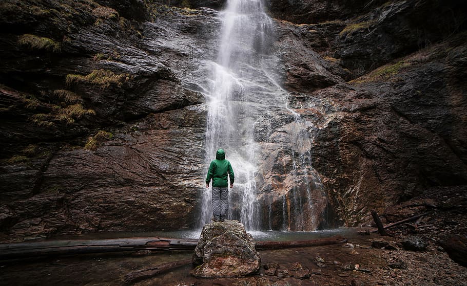 man standing in front of waterfall taken during daytime, flow HD wallpaper