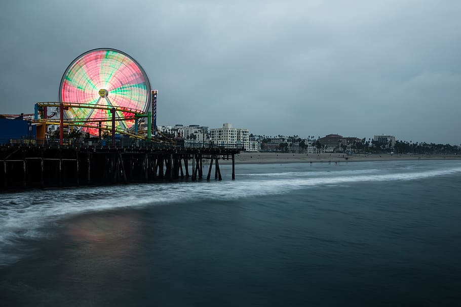 lighted Ferris wheel in the city near body of water, dock standing on body of water HD wallpaper