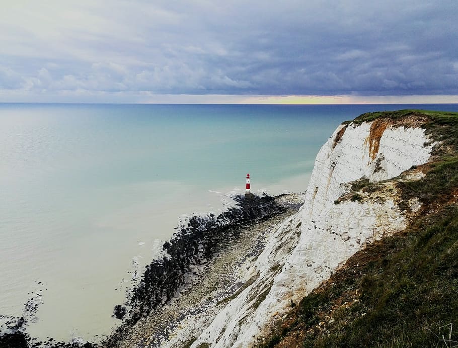 South coast, England, lighthouse on cliff overlooking sea at daytime HD wallpaper