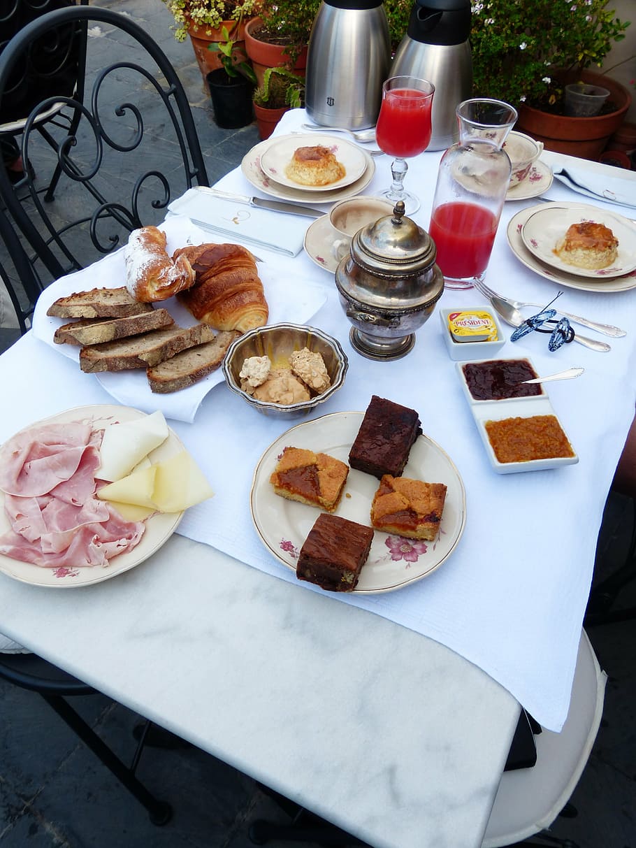 baked breads, clear drinking glasses, and food placed on white table HD wallpaper