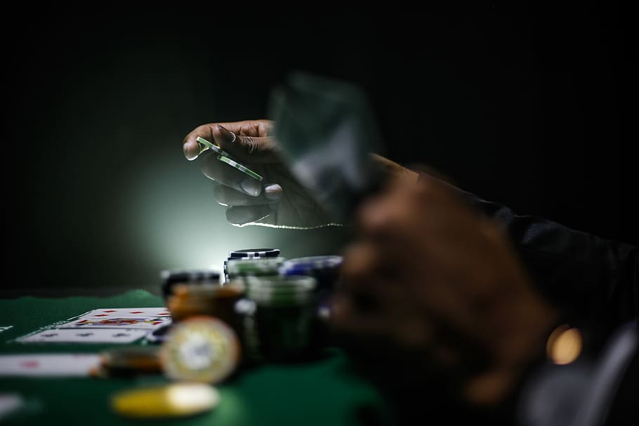 selective focus photography of poker chips, person playing poker