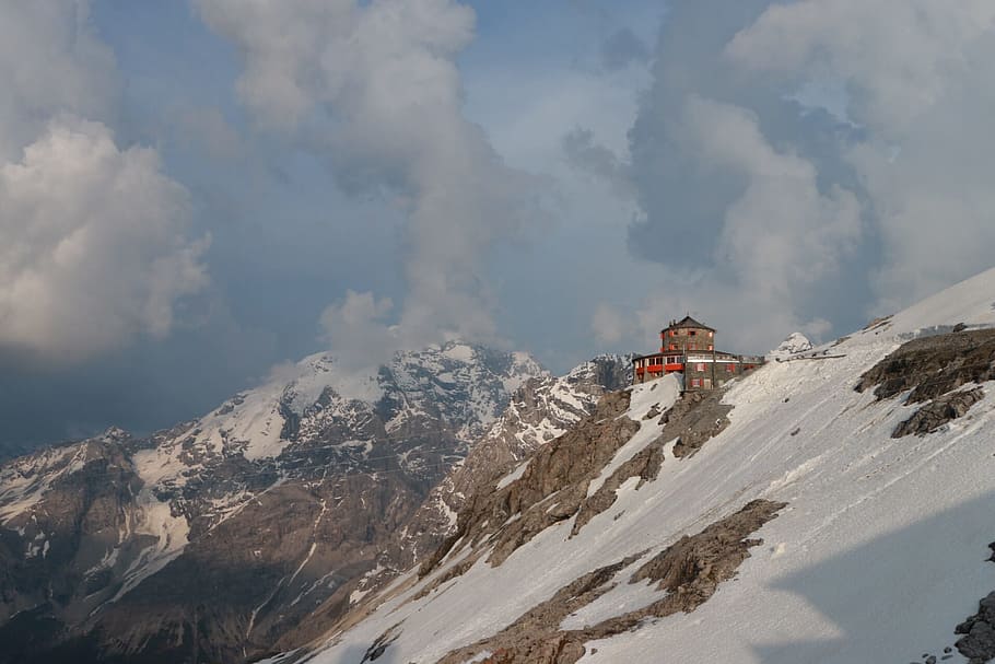 house on top of mountain under cloudy sky, brown and red building on top of snow capped mountain, HD wallpaper