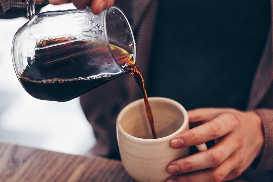 person pouring coffee on mug, photo of person holding pitcher filled with liquid pouring into cup HD wallpaper
