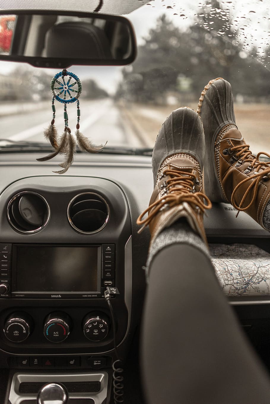 person wearing duck boots putting his boots on vehicle glove compartment, person inside vehicle hanged its feet on dashboard HD wallpaper