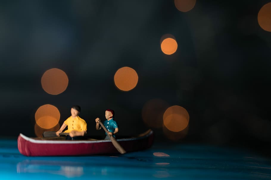 bokeh photography of two men riding canoe scale model, two men in canoe figurine, HD wallpaper