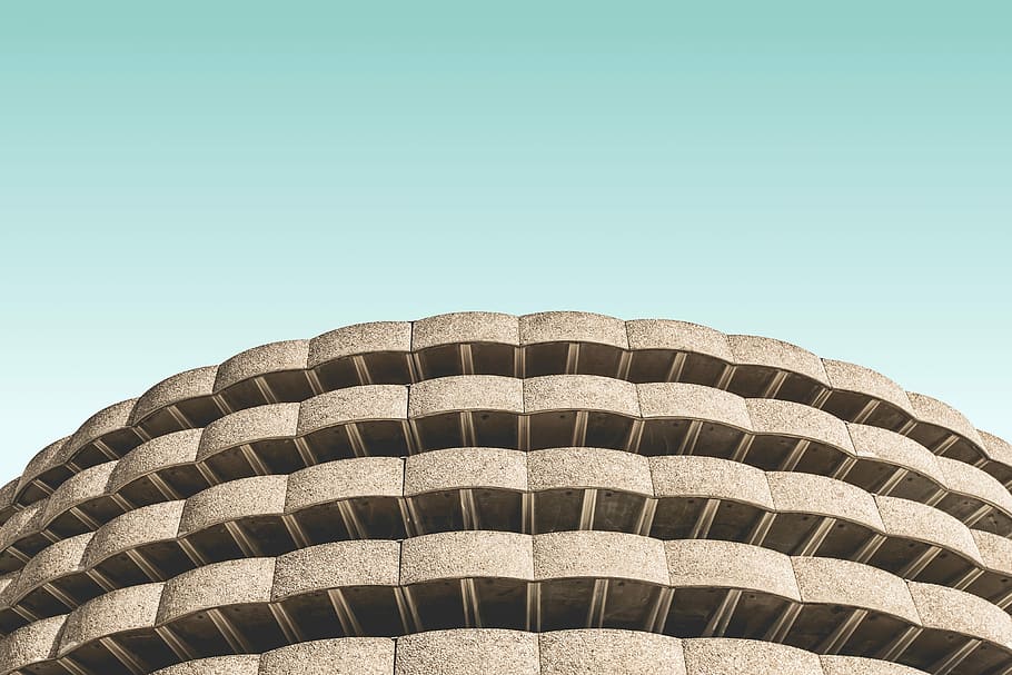 low angle photo of brown concrete building, gray concrete building under teal sky HD wallpaper