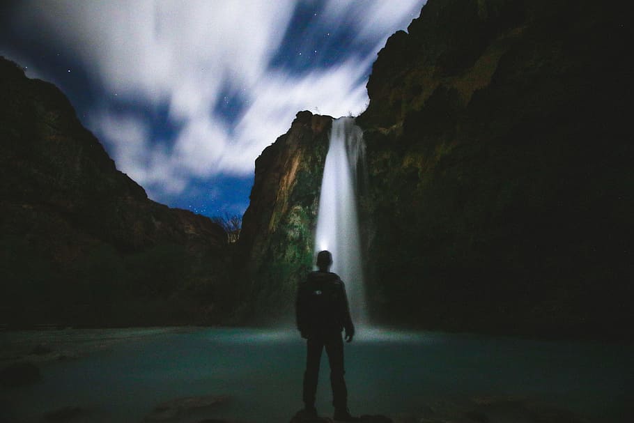 man standing in front of body of water, man standing in front of waterfall