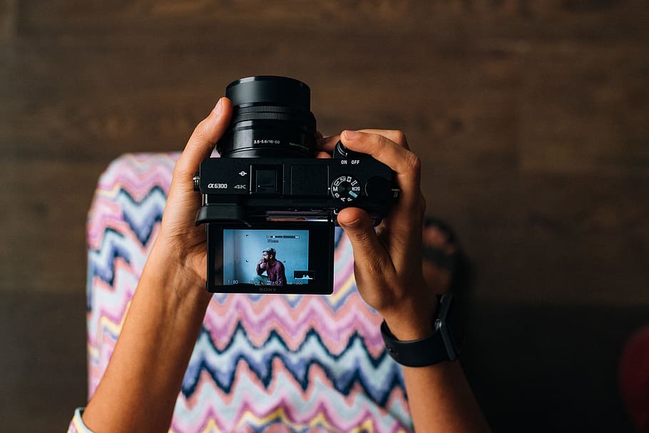 person holding black DSLR camera, person holding black SLR camera HD wallpaper