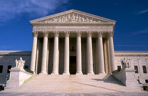 Download Supreme Court Building Behind American Flag Wallpaper