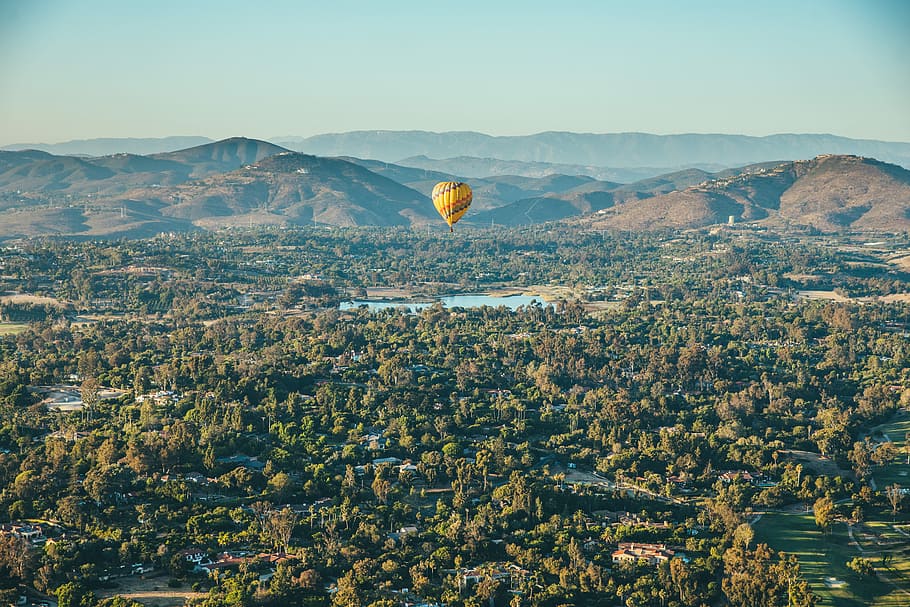 yellow hot air balloon with green trees under, aerial photo of hot air balloon HD wallpaper