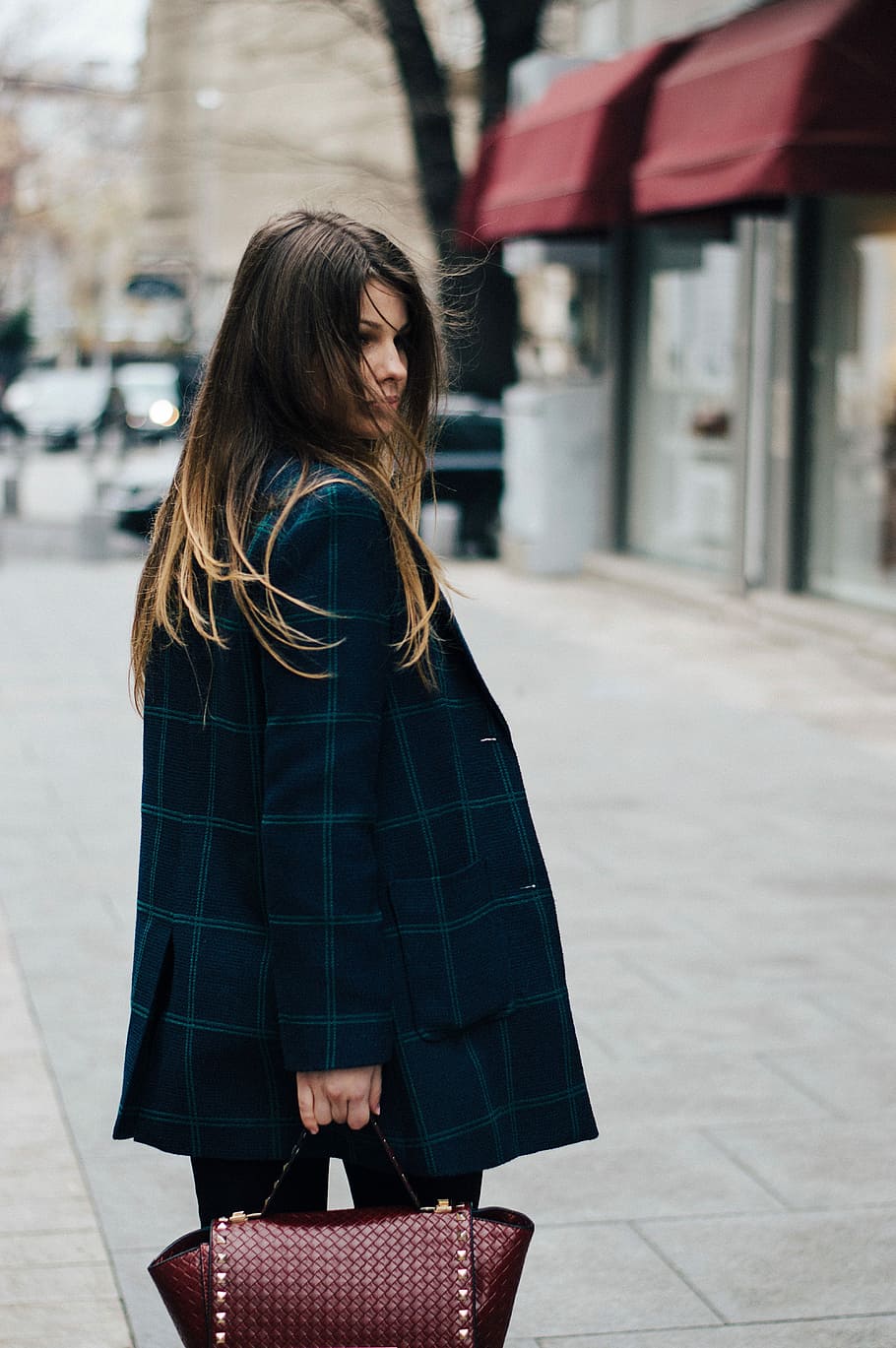 woman in blue check coat holding brown leather handbag during daytime HD wallpaper
