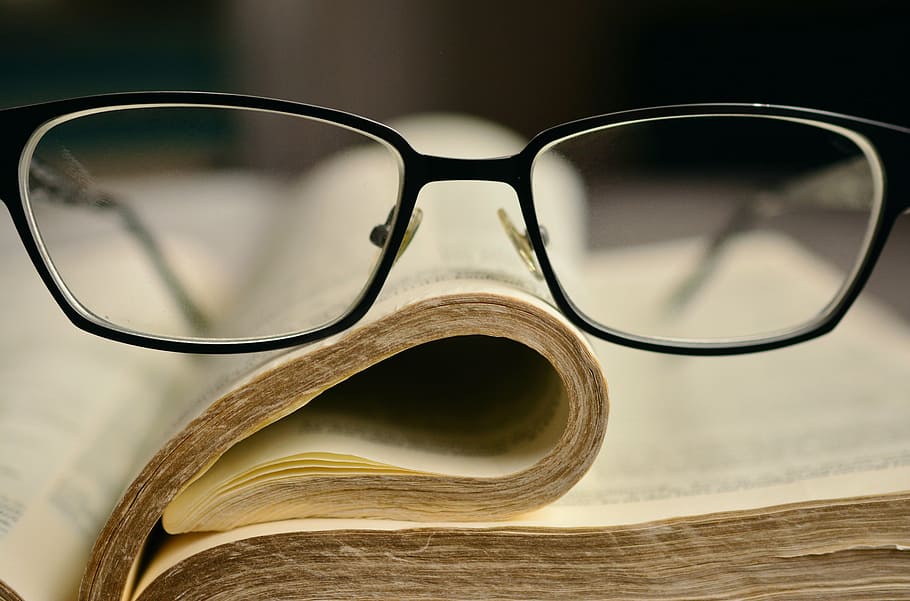 black frame eyeglasses on book page, bible, holy scripture, book pages