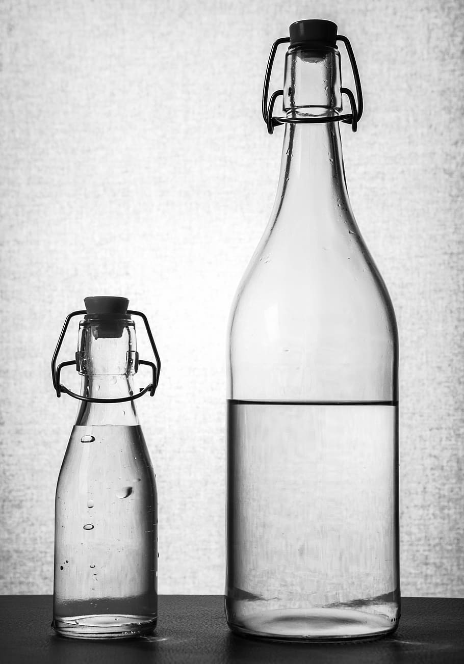 two glass bottles with clear liquid inside, water bottle, drink