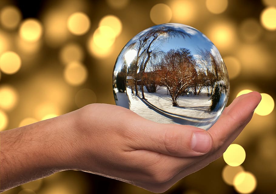 person holding snow globe, glass ball, winter, mirroring, hand