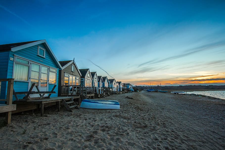 inline blue and brown wooden houses near shoreline under blue sky at daytime HD wallpaper