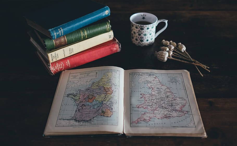 assorted books, blur, close-up, focus, map, mug, pile, table HD wallpaper