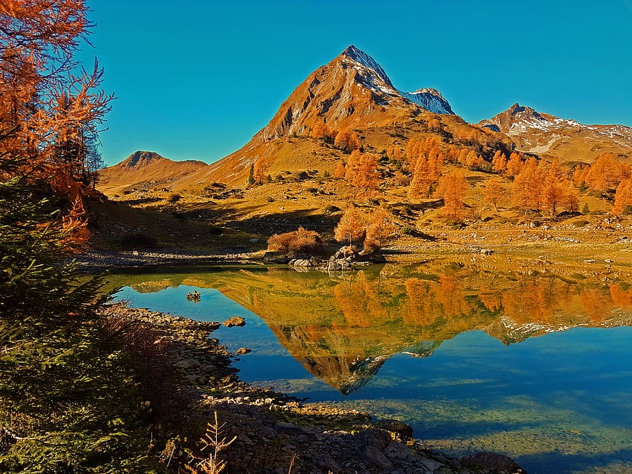 landscape photography of mountain, brown mountain near body of water during daytime HD wallpaper