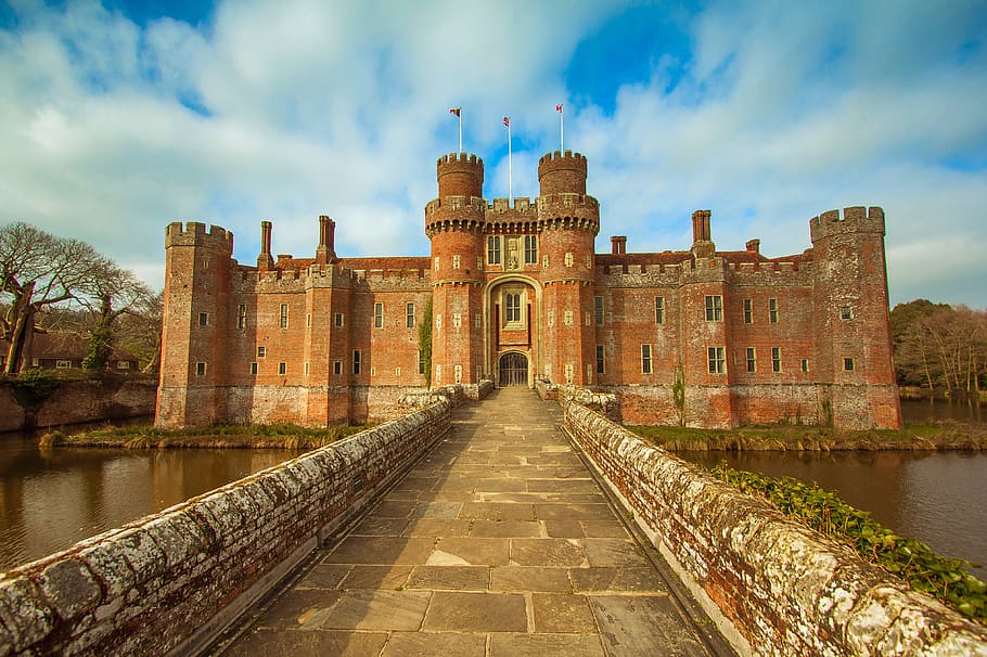 red castle near body of water, herstmonceux castle, east sussex